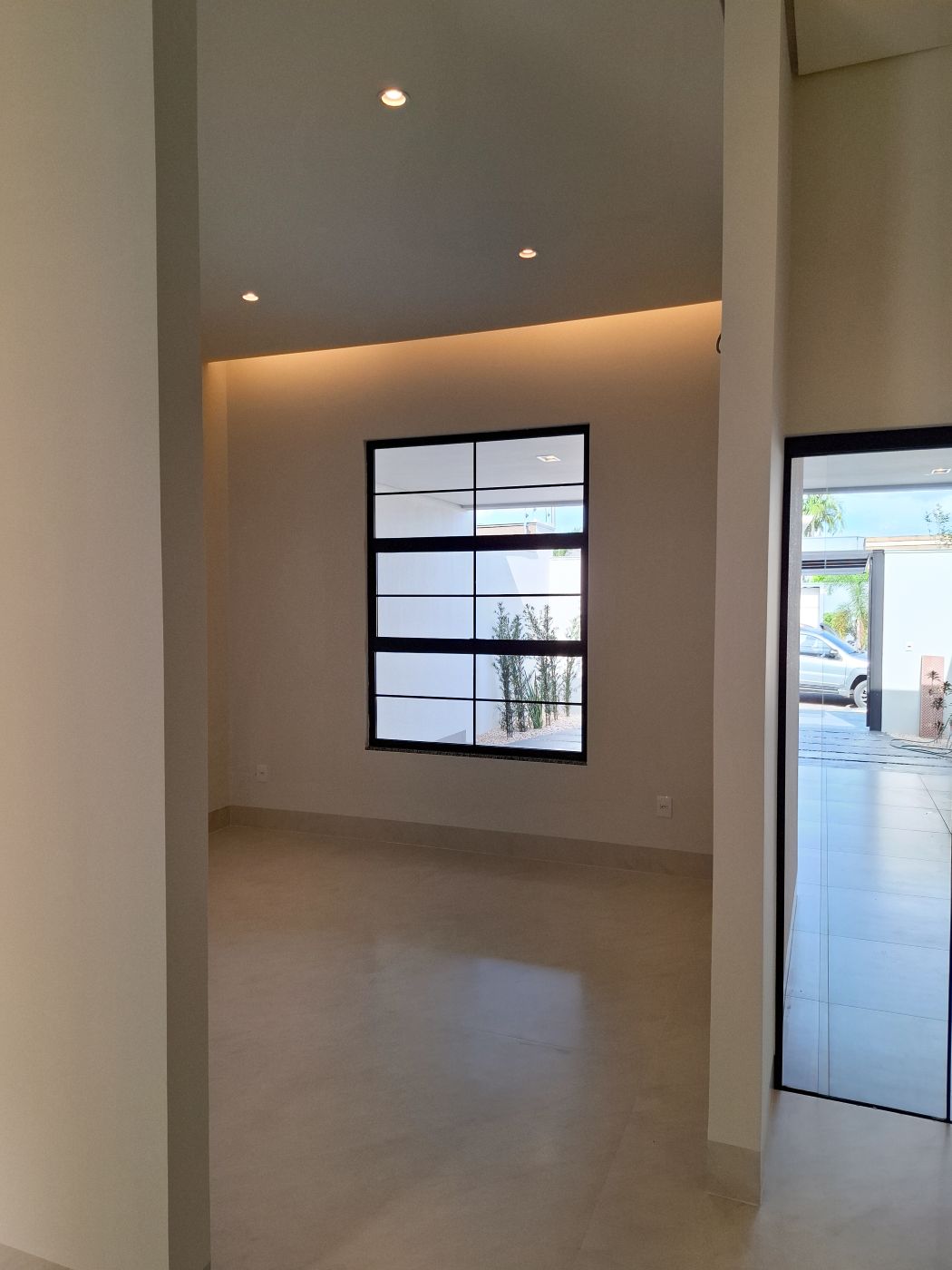 Sala com sanca iluminada e porta de vidro para a garagem