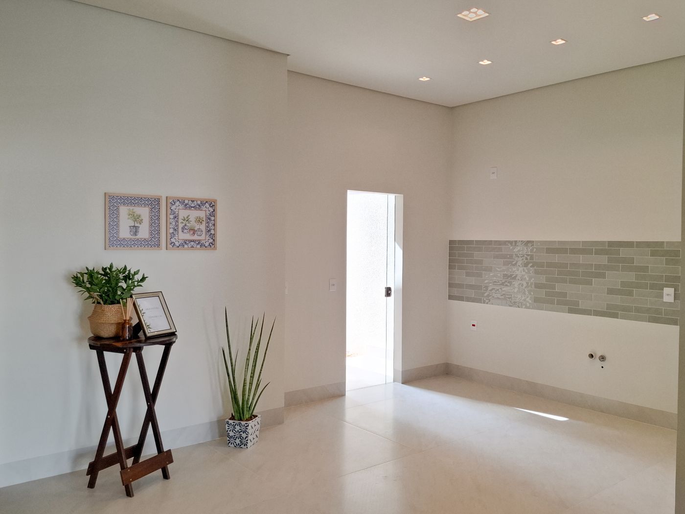 Cozinha com faixa de revestimento e quadros decorativos
