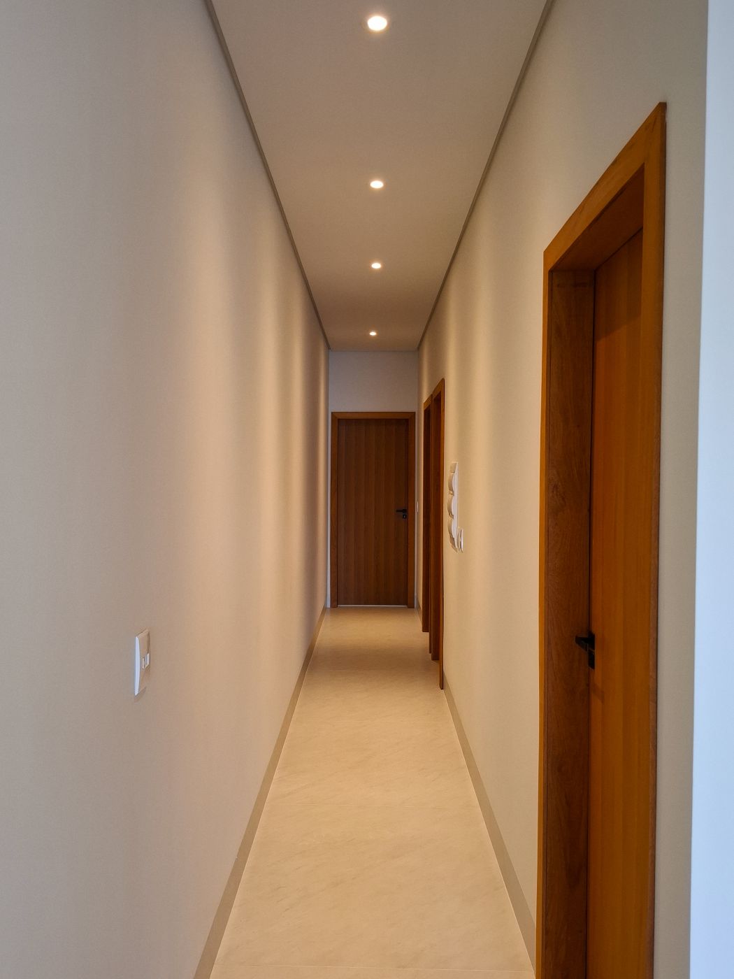 Corredor dos quartos, com portas de madeira
