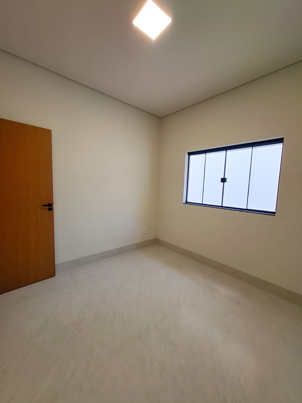 Quarto com porta de madeira e janela