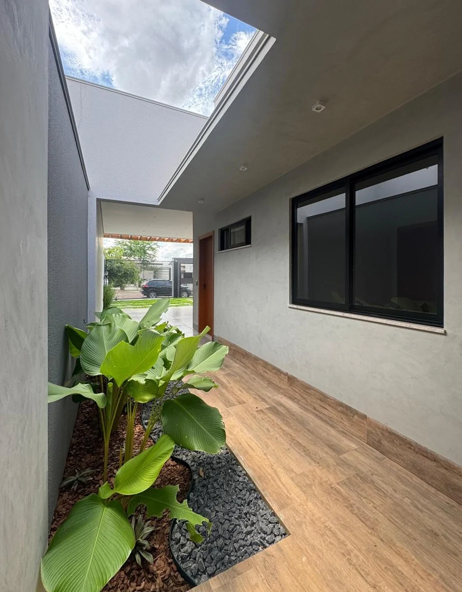 Jardim interno com bananeira e piso de madeira