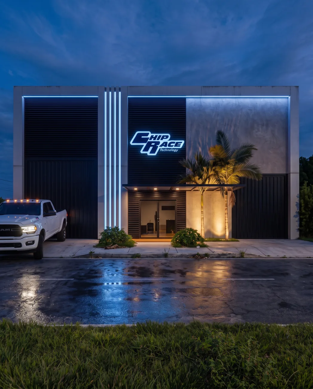 Fachada de oficina e showroom de carros à noite, com letreiro luminoso